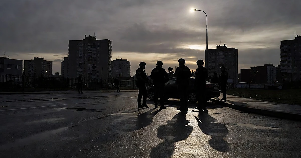 Silhouettes of law enforcement officers during an urban enforcement operation at dusk with dramatic backlighting